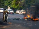 Un hombre en motocicleta atraviesa una barricada de fuego en Myanmar