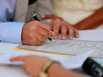 Matrimonio firmando el registro del Libro de Familia.