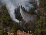 Un helicóptero del Gobierno de Canarias descarga agua sobre una de las zonas del incendio en el municipio de Arico, Tenerife.