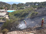 Bomberos controlan el incendio en una montaña cerca del parque Aquopolis de Cullera.