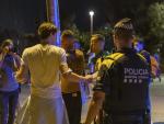 Un agente de la Guardia Urbana desaloja a jóvenes de la playa de la Barceloneta tras la entrada en vigor del toque de queda en Cataluña.