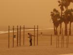 Un joven hace deporte en la playa de Aguadulce, Roquetas de Mar ( Almería) bajo la intensa calima