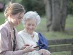 Jubilada con una familia mirando la pensión en el móvil