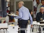 Camarero porta una bandeja en una terraza en un bar de Madrid