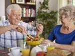 Una pareja de jubilados disfruta de una comida saludable en la mesa
