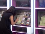 Una mujer compra su billete en las taquillas de venta automática de la estación de tren de Atocha