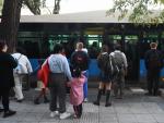 Varias personas delante de un bus de la EMT en el barrio de Puente de Vallecas, a 27 de septiembre de 2023, en Madrid