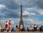france_paris_people_walk_by_the_eiffel_tower_the_symbol_of