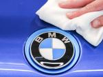 Un empleado de BMW saca brillo al logo de la marca.