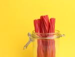 closeup-shot-red-licorice-sticks-jar-yellow-background