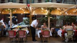 Un camarero atiende a una mesa en las Ramblas, en Barcelona