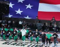 Varios jugadores de los Boston Celtics se arrodillan para protestar contra el racismo antes de comenzar un partido.