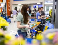 Una joven utiliza uno de los sistemas para cobrarse por sí mismo recién instalados en Walmart.
