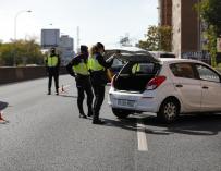 Varios agentes de Policía Nacional inspeccionan un vehículo en un control en la carretera A-5, en Madrid.