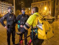 Unos policías informan en Zaragoza a un repartidor sobre la aplicación del toque de queda desde las 23.00 a las 06.00 horas