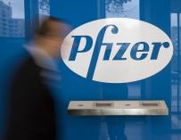 Un hombre camina ante el logo de Pfizer, en Berlín.