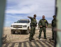 Varios patrulleros fronterizos de Estados Unidos vigilan los trabajos de refuerzo en el muro con México .