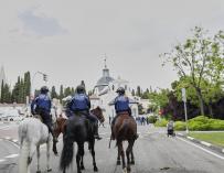 Agentes de la Unidad Equestre de la Policía Municipal de Madrid patrullan por las inmediaciones de la pradera de San Isidro.