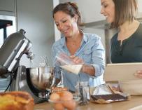 Dos mujeres preparan una receta en un robot de cocina
