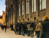 Decenas de personas hacen cola para compra deuda del Tesoro en el Banco de España.