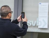 Un cliente toma una foto del aviso de la FDIC a los clientes del SVB.