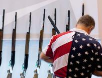 Un estadounidense con una camisa muy patriótica elige rifle