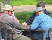 Fotografía de varios jubilados jugando al dominó.