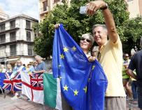 Una pareja se toma un selfie junto a la bandera de europea en Málaga durante una protesta contra el Brexit