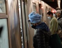Una mujer con mascarilla y pantalla protectora en el metro de Nueva York
