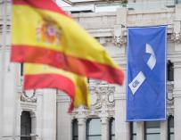 Bandera de España y bandera con el lazo que simboliza la lucha unida del pueblo de Madrid en la fachada del Ayuntamiento de Madrid