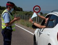 Un conductor enseña la documentación a un mosso en un control en la zona confinada de Lleida.