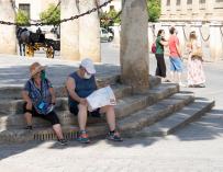 Dos turistas buscan la sombra en pleno centro de Sevilla durante este verano.
