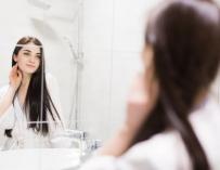Una joven se mira al espejo