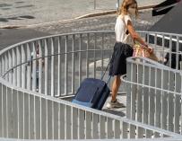 Una joven turista acarrea una maleta durante las vacaciones de 2020.