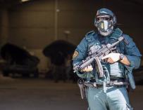 Un agente de la Guardia Civil vigila en la puerta de un hangar en una operación contra la droga en el sur.