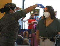 Una militar toma la temperatura a la pasajera de un barco, en Melilla.