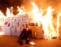 Mienbros de los Comités de Defensa de la República (CDR) queman un retrato del rey Felipe VI, hoy viernes tras la manifestación convocada por la CUP en el centro de Barcelona con motivo de la Diada.