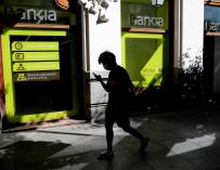 Un transeúnte pasa por delante de una oficina de Bankia.
