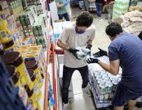 Trabajadores reponiendo productos en un supermercado
