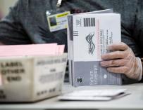 Un trabajador electoral verifica las firmas en los votos por correo en busca de irregularidades en el centro de procesamiento de votos por correo de los registradores del condado de Los Ángeles en Pomona Fairplex en Pomona, California