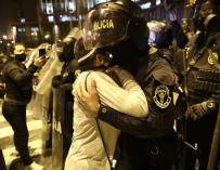 Una manifestante se abraza a una policía durante las protestas en Lima contra el Gobierno.