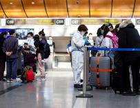 Empleados revisan la temperatura de los pasajeros en el Aeropuerto Internacional LAX en Los Ángeles, California