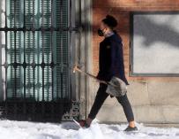 Un joven lleva una pala para despejar de nieve su calle en las inmediaciones de Atocha, en Madrid.