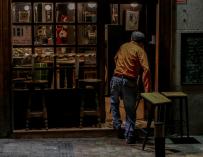 Un hombre cierra su restaurante el día en el que se adelanta el cierre de hostelería a las 22.00h, en Madrid.