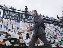 28 May 2020, US, New York: A man wearing a mask walks past a memorial for Coronavirus (Covid-19) victims hangs from a fence at the entrance to The Green-Wood Cemetery. Photo: Bryan Smith/ZUMA Wire/dpa (Foto de ARCHIVO) 28/5/2020 ONLY FOR USE IN SPAIN