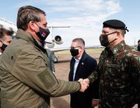 Jair Bolsonaro saluda a un militar en el aeropuerto internacional de Bage.