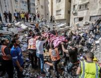 Paramédicos palestinos desentierran el cuerpo de una persona en una casa colapsada por un ataque de las fuerzas israelíes.