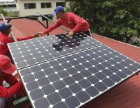Operarios instalando placas solares en un edificio