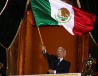 Andres Manuel López Obrador ondea la bandera mexicana.
