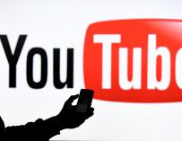 FILED - 15 March 2019, Schleswig-Holstein, Aukrug-Homfeld: A man holds a smartphone in front of the logo of YouTube. Pakistan has asked video-sharing platform YouTube to block "vulgarity and hate speech" for viewers in the country, stoking fears of censorship. Photo: Carsten Rehder/dpa (Foto de ARCHIVO) 15/3/2019 ONLY FOR USE IN SPAIN